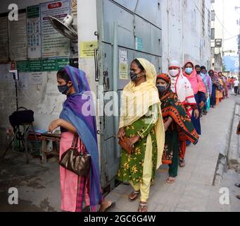 Août 05,2021,Dhaka,Bangladesh: Le personnel de sécurité vérifie la température corporelle des travailleurs de l'habillement avant d'entrer dans une usine de vêtement après le fait de vêtement Banque D'Images