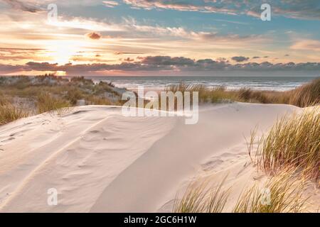 Coucher de soleil vue depuis une dune au-dessus de la mer du Nord de l'île d'Ameland, Frise, Pays-Bas Banque D'Images