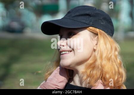 Fille dans une casquette et une veste. Portrait d'un adolescent en automne. Femme dans une casquette dans la rue. Banque D'Images