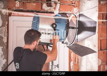 Derrière la scène. Technicien en éclairage de la réalisation de films ingénieur en électricité pour régler et configurer les lumières pour la scène de film. Rayon lumineux. Équipe de tournage Banque D'Images