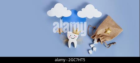 Journée nationale de la fête des Tooth. Fée dentaire pour enfants. Dent mignonne avec des ailes, une couronne et une baguette magique et un sac avec des dents. Banque D'Images