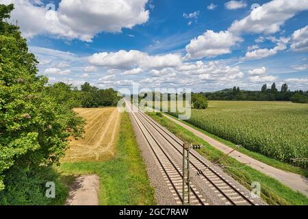 les voies de chemin de fer sont parallèles dans le lit de voie, en arrière-plan un beau paysage avec des nuages blancs et le ciel bleu Banque D'Images