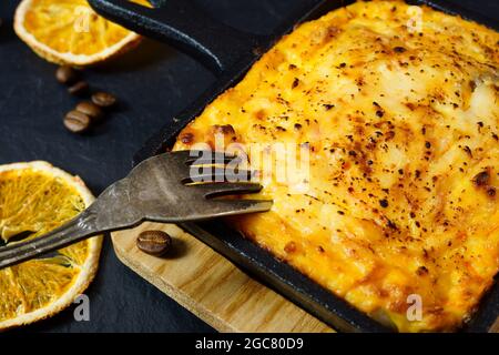 Cocotte de fromage cottage dans une poêle en fonte. La fourchette est dans la nourriture. Gros plan Banque D'Images