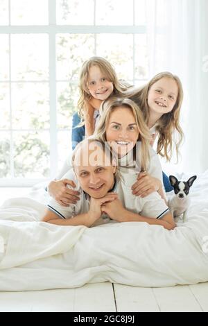 Une famille gaie assise sur un canapé dans la salle de séjour s'amuser à rire ensemble, à profiter de son temps libre et à jouer à la maison. Activité week-end, lif famille heureux Banque D'Images