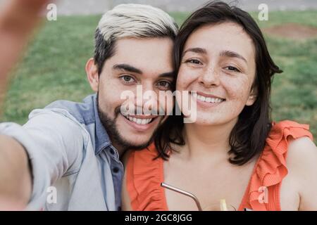 Jeune hipster couple prenant le portrait selfie avec téléphone mobile en plein air dans la ville - amis touristiques et les vacances de week-end - foyer principal sur la fille Banque D'Images