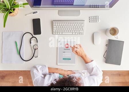 La vue de dessus d'une femme médecin méconnaissable utilise sa tablette numérique Banque D'Images