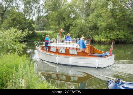 Les gens qui conduisent un bateau de plaisance sur la Tamise à Abingdon sur la Tamise Oxfordshire Angleterre Banque D'Images