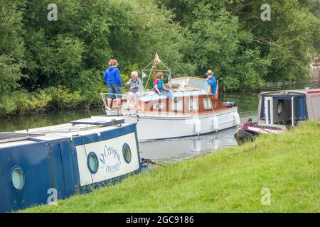 Les gens qui conduisent un bateau de plaisance sur la Tamise à Abingdon sur la Tamise Oxfordshire Angleterre Banque D'Images