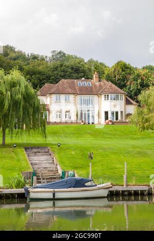 Maison sur la Tamise à Goring sur la Tamise Oxfordshire avec un bateau amarré au fond du jardin Banque D'Images
