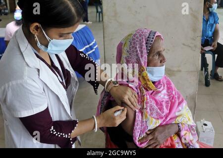 Dhaka, Bangladesh, 7 août 2021. Une infirmière applique une dose à une personne pendant une campagne de vaccination de masse, afin de réduire le risque de contagion contre la nouvelle variante Delta de Covid-19. Le Gouvernement bangladais a mis en œuvre un programme de vaccination visant à vacciner la majorité de la population en 6 jours, afin de réduire la propagation du coronavirus. Credit: Habibur Rahman / Groupe Eyepix / Alamy Live News Banque D'Images