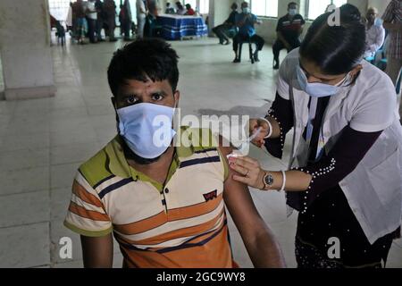 Dhaka, Bangladesh, 7 août 2021. Une infirmière applique une dose à une personne pendant une campagne de vaccination de masse, afin de réduire le risque de contagion contre la nouvelle variante Delta de Covid-19. Le Gouvernement bangladais a mis en œuvre un programme de vaccination visant à vacciner la majorité de la population en 6 jours, afin de réduire la propagation du coronavirus. Credit: Habibur Rahman / Groupe Eyepix / Alamy Live News Banque D'Images