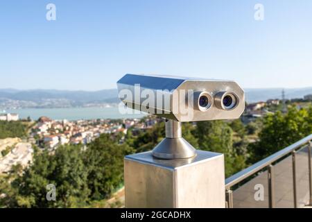 Les jumelles de télescopes touristiques à pièces donnent sur la vue sur le paysage de la ville Banque D'Images