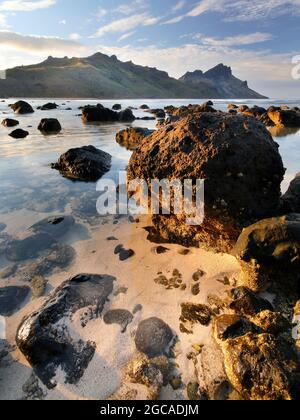 rochers et lumière du soleil sur la côte près des montagnes sur la plage Banque D'Images