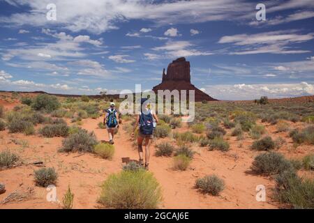 Randonnée pédestre sur le sentier Wildcat Trail dans le parc tribal de Monument Valley Navajo, États-Unis. Une journée chaude d'août avec ciel bleu et falaises de grès, buttes, et pinacles. Est Banque D'Images