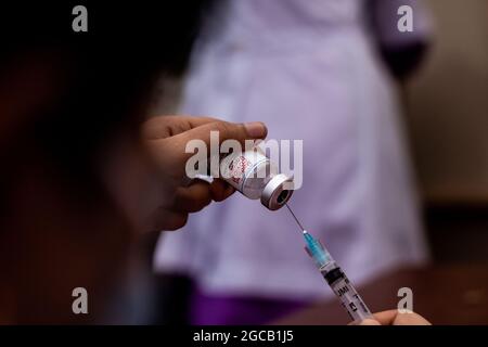 Barishal, Bangladesh. 07e août 2021. Une infirmière est vue se préparer une dose de Moderna Vaccine à un stand de vaccination de l'hôpital Arife Memorial car c'est un programme de vaccination de masse par le gouvernement qui a commencé le 7 août.des milliers de personnes sont vues se rassembler pour prendre les vaccins et les infirmières ont été vues à vous avez un temps chargé toute la journée. (Photo de MD Niamul Hossain Rifat/Pacific Press) crédit: Pacific Press Media production Corp./Alay Live News Banque D'Images