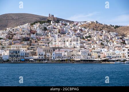 Île de Syros, Cyclades, Grèce. Ville d'Ermoupolis, front de mer bâtiments traditionnels en haut de la colline, vue de la mer. Jour d'été ensoleillé, ciel bleu Banque D'Images