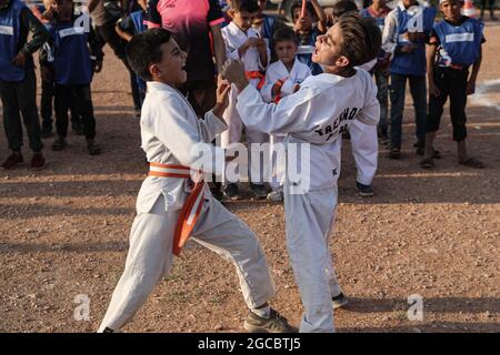 Idlib City, Syrie. 07e août 2021. Deux enfants syriens jouent un match de karaté dans le cadre d'une petite manifestation de style olympique organisée à l'intention des enfants déplacés par des volontaires de l'organisation de secours Violet. L'événement sportif est organisé en conjonction avec les Jeux Olympiques de Tokyo en 2020 pour attirer l'attention sur les conditions à l'intérieur des camps de réfugiés de ceux qui ont été contraints à des déplacements internes à la suite du conflit civil syrien. Credit: Aras Alkharboutli/dpa/Alamy Live News Banque D'Images