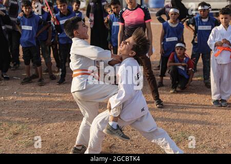 Idlib City, Syrie. 07e août 2021. Deux enfants syriens jouent un match de karaté dans le cadre d'une petite manifestation de style olympique organisée à l'intention des enfants déplacés par des volontaires de l'organisation de secours Violet. L'événement sportif est organisé en conjonction avec les Jeux Olympiques de Tokyo en 2020 pour attirer l'attention sur les conditions à l'intérieur des camps de réfugiés de ceux qui ont été contraints à des déplacements internes à la suite du conflit civil syrien. Credit: Aras Alkharboutli/dpa/Alamy Live News Banque D'Images