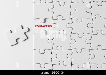 Contactez-nous message écrit sur pièce de puzzle manquante sur fond blanc. Banque D'Images