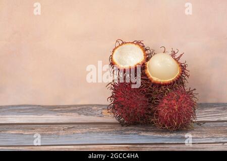 Fruits locaux appelés rambutan, variante rouge qui est la plus commune. Le rambutan est un fruit tropical de la famille des baies de savon. Mise au point sélective. Arrière-plan flou Banque D'Images