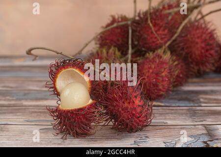 Fruits locaux appelés rambutan, variante rouge qui est la plus commune. Le rambutan est un fruit tropical de la famille des baies de savon. Mise au point sélective. Arrière-plan flou Banque D'Images