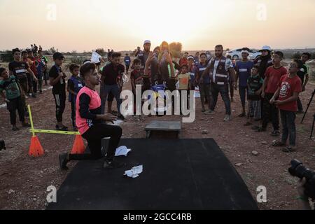 Idlib City, Syrie. 07e août 2021. Un enfant syrien participe à un match d'athlétisme dans le cadre d'un petit Jeux Olympiques organisé pour les enfants déplacés par l'Organisation Violet pour le secours et le développement. L'événement sportif est organisé en conjonction avec les Jeux Olympiques de Tokyo en 2020 pour sensibiliser les populations des camps de réfugiés contraintes à leur déplacement interne en raison du conflit civil en Syrie. Credit: Aras Alkharboutli/dpa/Alamy Live News Banque D'Images