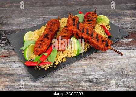 Brochettes de viande de poulet au Chili cuites au barbecue sur des brochettes de bois avec un repas de riz Banque D'Images