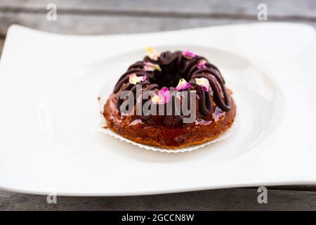 Petit gâteau avec chocolat sur une assiette blanche Banque D'Images