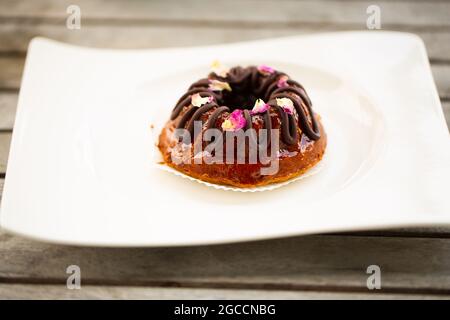 Petit gâteau avec chocolat sur une assiette blanche Banque D'Images
