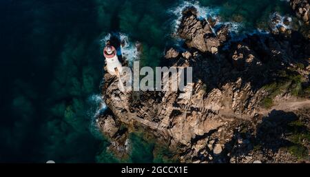 Vue de dessus, superbe vue aérienne d'une vieille et belle plage situé sur une côte rocheuse baignée par une mer agitée. Banque D'Images