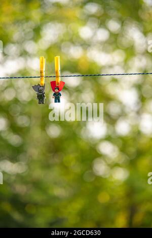 LEGO mini-figurines batman et superman sur une corde à linge Banque D'Images