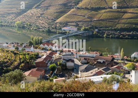 Vue d'automne ensoleillée le matin sur un pont au-dessus de la rivière Duoro et du village de Pinhao au Portugal. Destinations de voyage et tourisme viticole au Portugal Banque D'Images