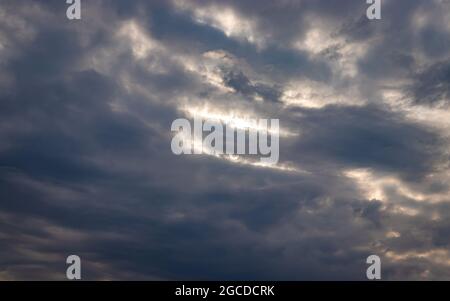 ciel nuageux avec soleil au crépuscule depuis un angle bas Banque D'Images