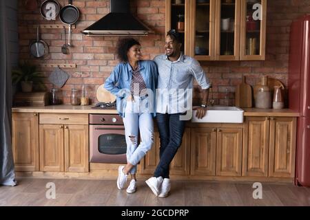 Un couple ethnique enthousiaste se détendre dans la cuisine Banque D'Images