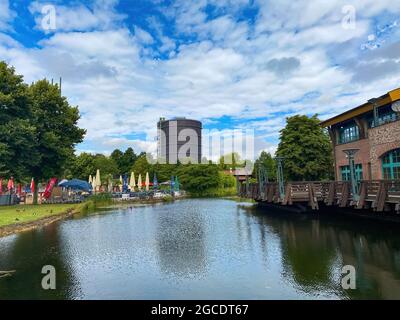 Oberhausen (Centro), Allemagne - juillet 9. 2021: Vue sur le canal d'eau au-delà de la plage sur la tour de gasometer contre le ciel d'été Banque D'Images