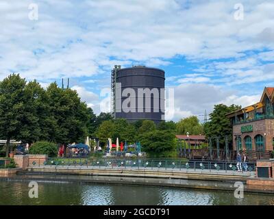 Oberhausen (Centro), Allemagne - juillet 9. 2021: Vue sur le canal d'eau au-delà de la plage sur la tour de gasometer contre le ciel d'été Banque D'Images