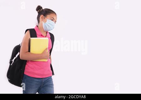 Jeune fille malheureuse étudiant tenant un carnet et portant un masque de protection Banque D'Images