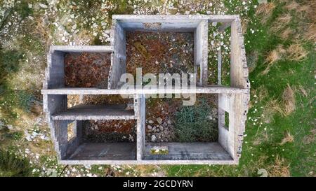Ruines d'un chalet dans un village abandonné. Intérieur de maison vide en pierre sans toit, vue aérienne directement au-dessus Banque D'Images