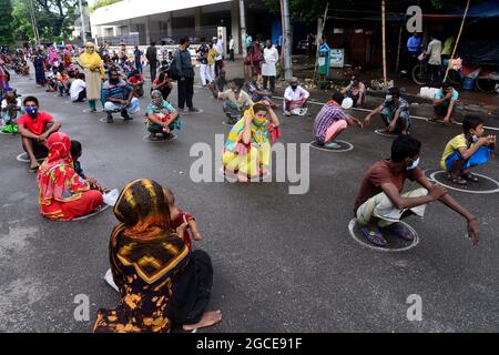 Dhaka, Bangladesh. 08 août 2021. Les pauvres font la queue attendent de recevoir de la nourriture de la police métropolitaine de Dhaka pendant le confinement imposé pour contenir la propagation du coronavirus Covid-19 dans la région de Poribag à Dhaka, au Bangladesh, le 8 août 2021 Credit: Mamunur Rashid/Alamy Live News Banque D'Images