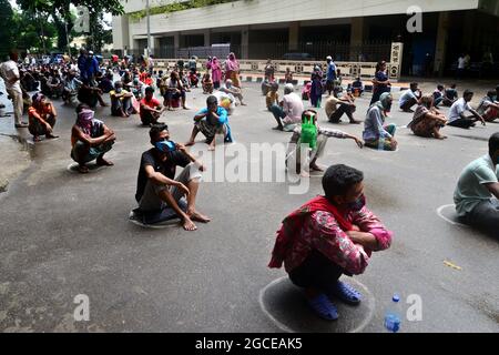 Dhaka, Bangladesh. 08 août 2021. Les pauvres font la queue attendent de recevoir de la nourriture de la police métropolitaine de Dhaka pendant le confinement imposé pour contenir la propagation du coronavirus Covid-19 dans la région de Poribag à Dhaka, au Bangladesh, le 8 août 2021 Credit: Mamunur Rashid/Alamy Live News Banque D'Images