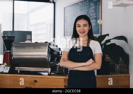 Dans son café, le propriétaire de l'entreprise ou le barista prend les commandes des clients. Banque D'Images