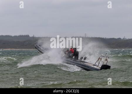 Bateau gonflable rigide, conditions météorologiques difficiles, mers de tempête, bateau à côtes, embarcation gonflable, Grandes vagues, rebondissement sur les vagues, bateau Rib par temps difficile. Banque D'Images