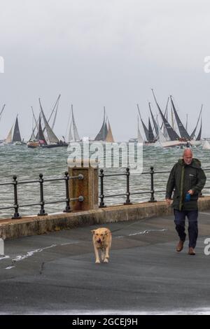 semaine des cowes, île de wight, marcheur de chien, homme avec chien, un homme et son chien, meilleur ami des hommes, régate de yachting, régate de voile, espace pour la copie. Banque D'Images