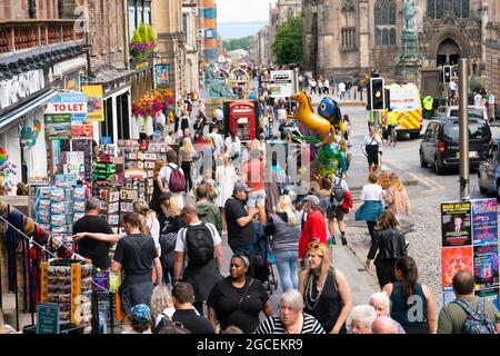 Édimbourg, Écosse, Royaume-Uni. 8 août 2021. Le dimanche après-midi ensoleillé, le Royal Mile était animé par des visiteurs à la recherche des divertissements limités offerts dans la rue pendant le festival frénétique d'Édimbourg cette année. Deux étapes sont prévues pour les interprètes et elles se sont avérées populaires tout au long de la journée. Pic ; les visiteurs du Royal Mile à Lawnmarket visitent les boutiques touristiques. Iain Masterton/Alamy Live News. Banque D'Images