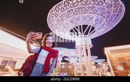 Femme touriste prenant la photo de selfie à la célèbre attraction touristique de Dubaï - Neon futuriste lumineux métal super arbres sur l'île bluewaters. Banque D'Images