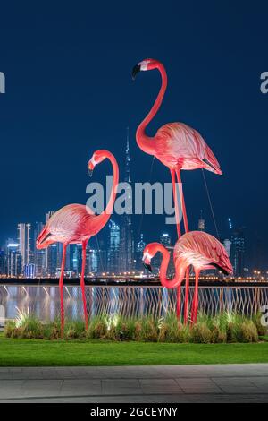 Attraction touristique populaire - statues décoratives de flamants roses sur le fond du plus grand gratte-ciel du monde - Burj Khalifa Banque D'Images