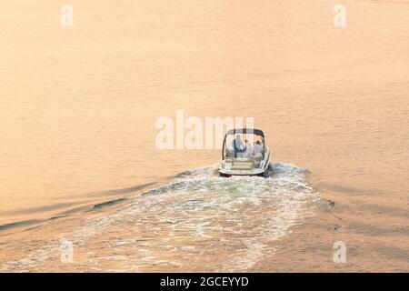 23 février 2021, Dubaï, Émirats arabes Unis : un petit bateau à moteur navigue le long du canal de Dubaï pour admirer le coucher du soleil pendant un week-end et se détendre Banque D'Images