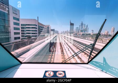 24 février 2021, Dubaï, Émirats Arabes Unis : vue depuis la voiture de devant du métro de Dubaï avec un panorama des rails et des gratte-ciels Banque D'Images