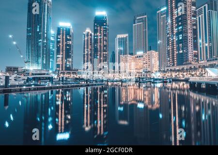 Hôtels et appartement résidentiel gratte-ciel bâtiments vue panoramique à Dubai Marina Creek Harbour la nuit avec des reflets dans l'eau Banque D'Images