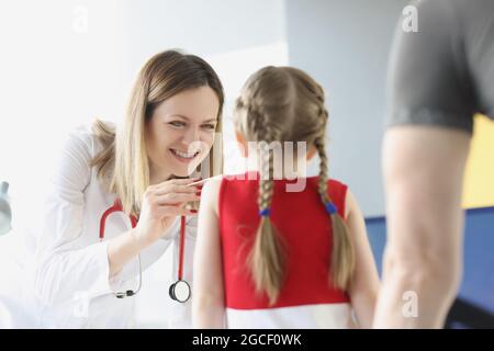 Le médecin examine la gorge et la bouche de la petite fille Banque D'Images